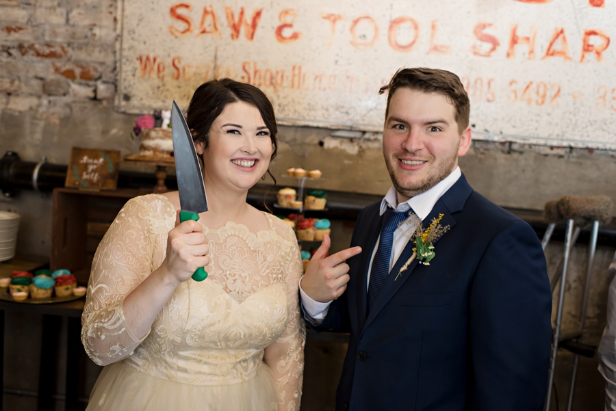 A bride and groom act silly before cutting the cake.